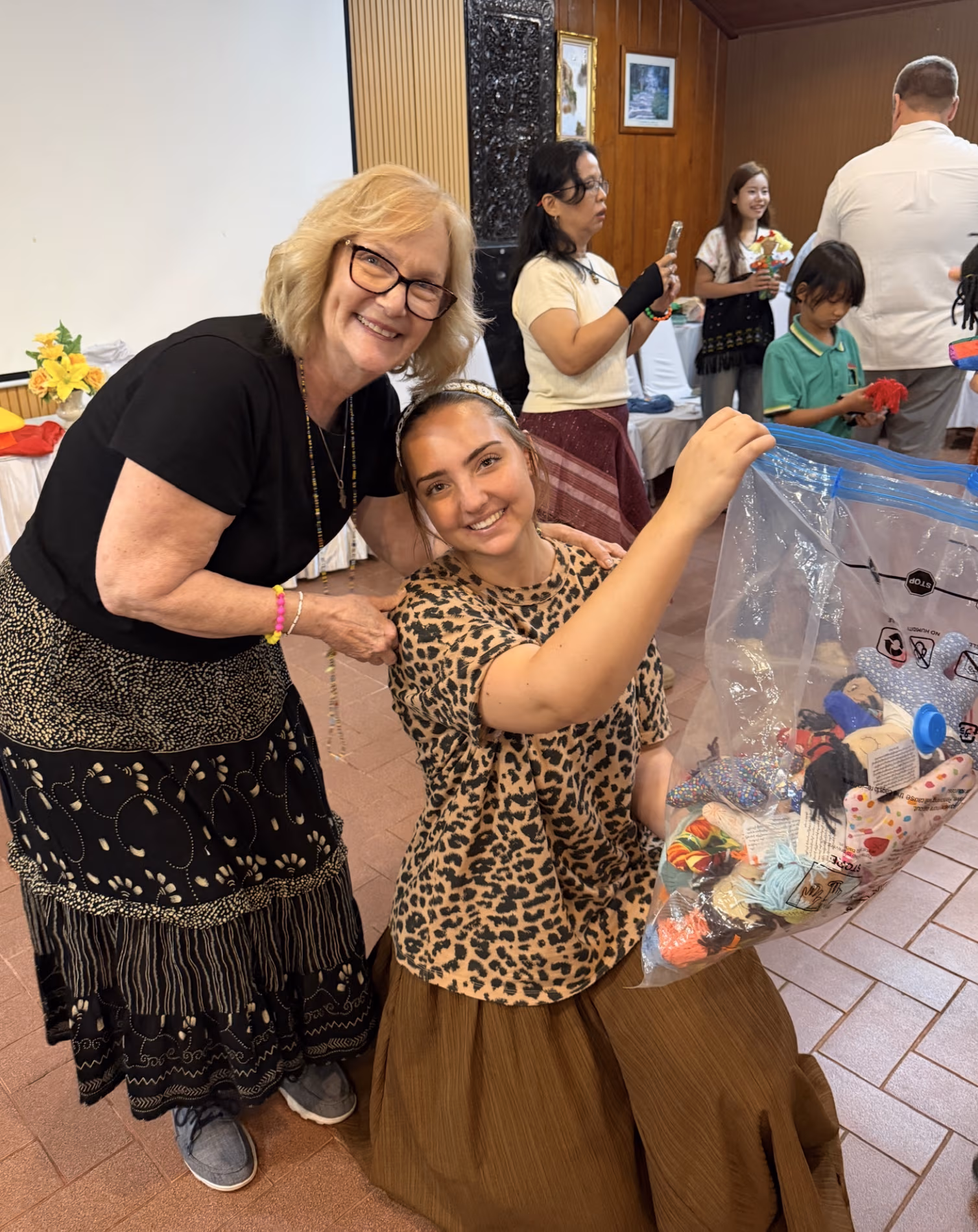 Dee and Joelle handing out the dolls to the girls